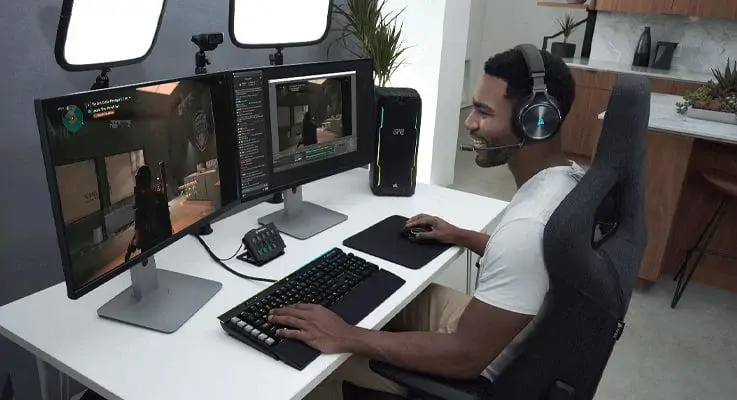 Mand med foran computer med Corsair Vitruoso RGB Wireless XT headset